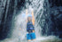 Guest standing under a waterfall during the Telaga Waja rafting stop