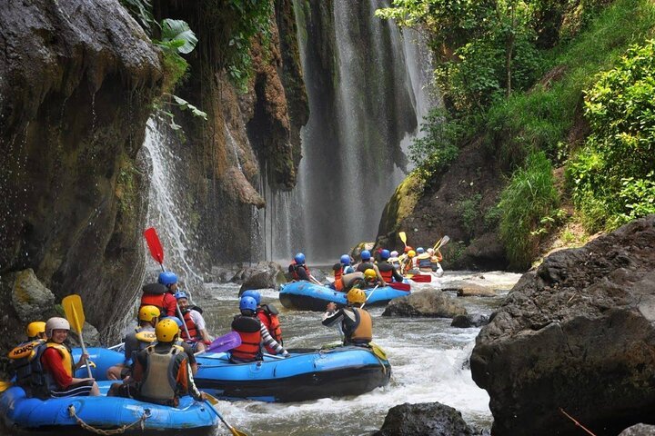 Rafts passing a jungle waterfall on the Telaga Waja River