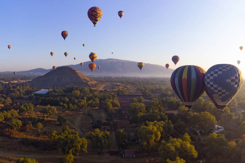 Hot air balloon experience over Teotihuacán, City of Gods, near Mexico City. Includes buffet, transportation. Witness sunrise over pyramids of Moon and Sun. 1-hour flight, brunch, and return to Mexico City. Departure from Ángel de la Independencia at 4:30 AM. Dress warmly."